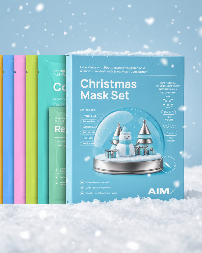 AIMX Christmas Mask Set displayed in snow, with colourful bio-cellulose mask sachets behind the blue gift box.