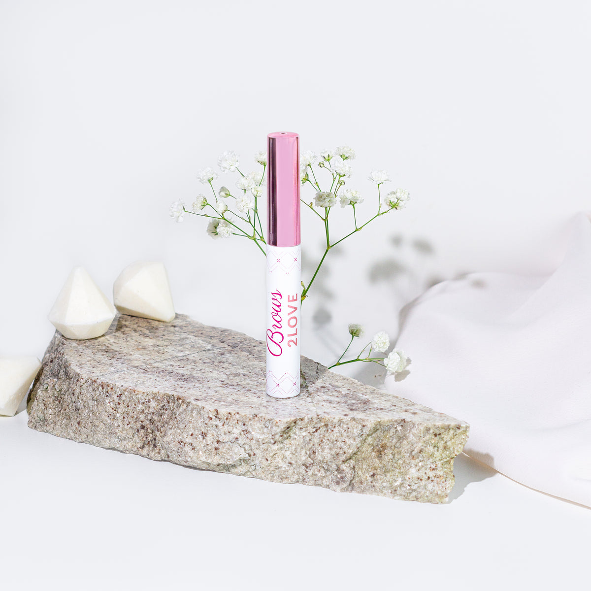 Lerelle Beauty Brows2Love eyebrow growth serum on stone with baby's breath flowers