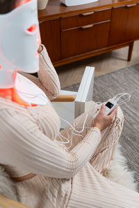 Lerelle Beauty red light therapy face and neck mask worn from the side, controlled with the remote