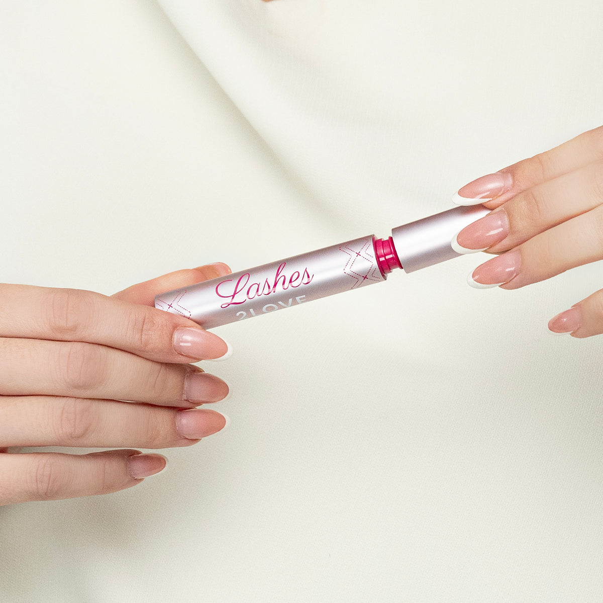 Lerelle Beauty Lashes2Love Biopeptides Lash Growth Serum tube held in hands, showing compact travel-friendly size