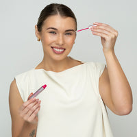 Lerelle Beauty Lashes2Love Biopeptides Lash Growth Serum, smiling model holding tube and applicator wand