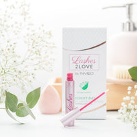 Lerelle Beauty Lashes2Love Biopeptides Eyelash Growth Serum tube open with applicator, spa flatlay scene