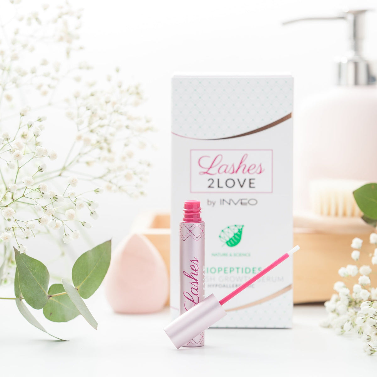 Lerelle Beauty Lashes2Love Biopeptides Eyelash Growth Serum tube open with applicator, spa flatlay scene