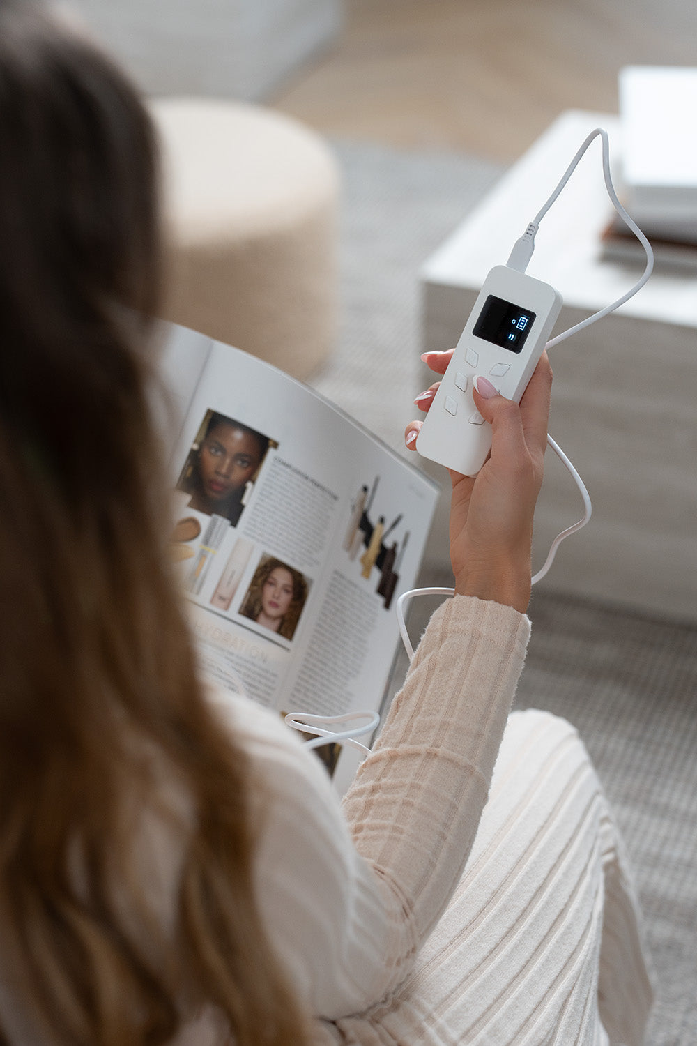 Lerelle Beauty LED mask remote control held in hand while reading a magazine